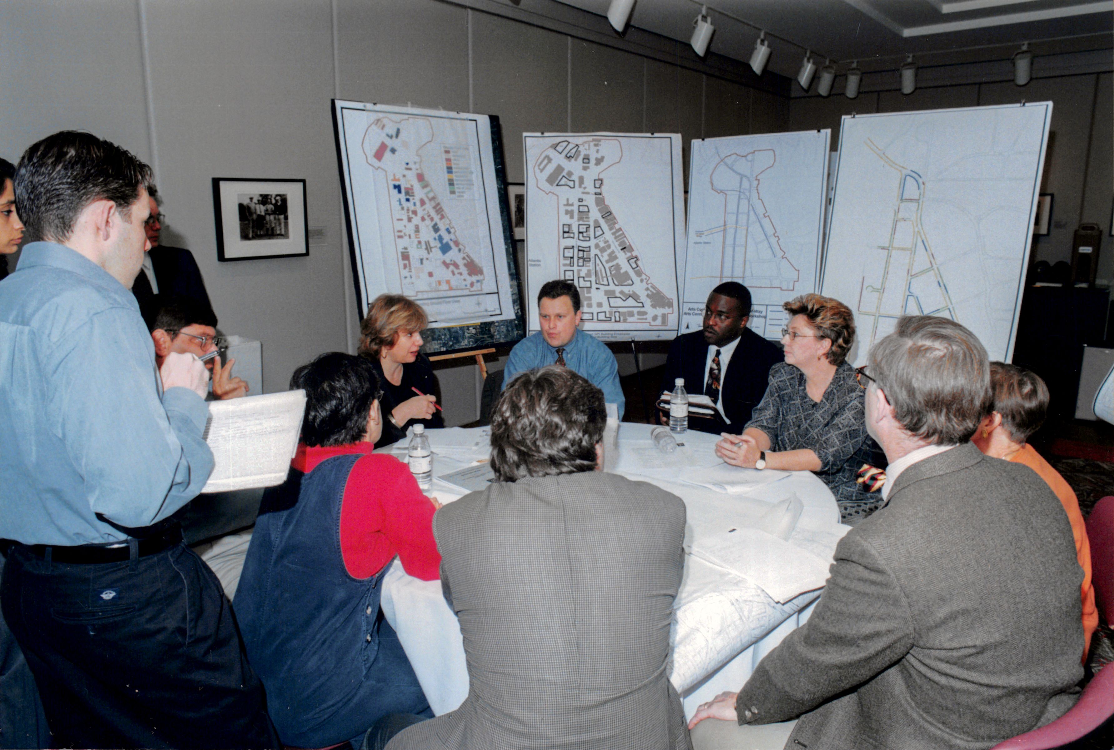 Executive sitting at a table discussing maps of Midtown