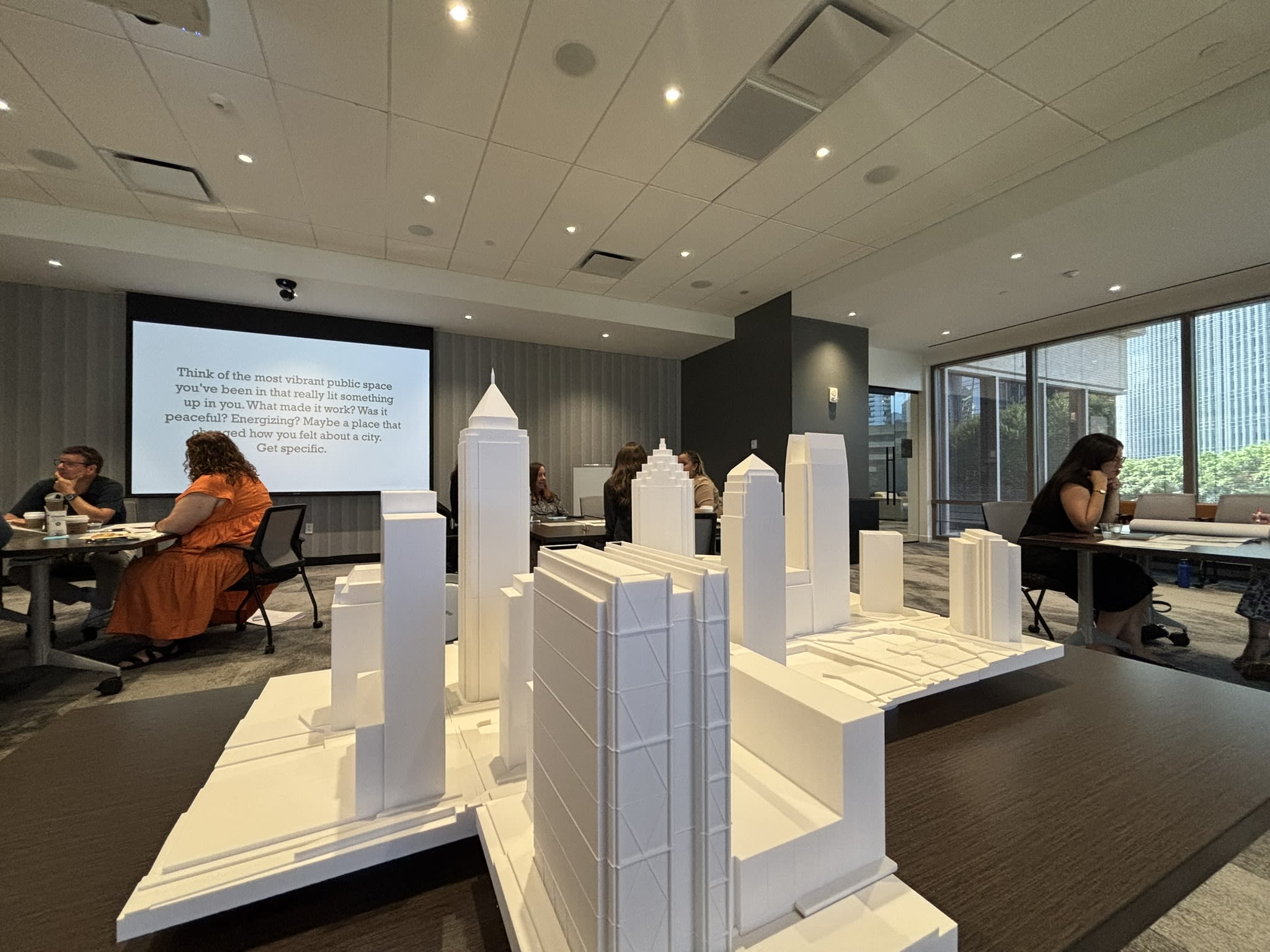People seated near a 3-D model of Midtown situated on a table